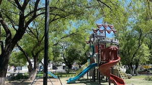 Un'area giochi con scivoli e strutture per arrampicarsi in un parco.
