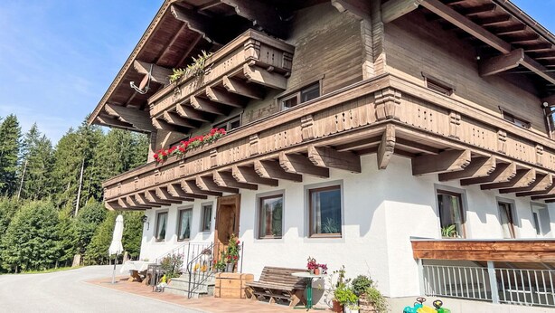 Un edificio de varios pisos con balcones de madera, fachada blanca y techo de madera.