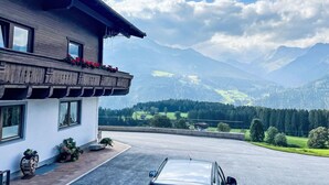 Un edificio moderno con un balcón que da a un paisaje montañoso.