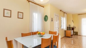 A dining area with a glass table, wooden chairs, and a fruit bowl. - Stunning private villa for 6 guests with private pool, A/C, TV, patio and pets allowed (L'almadrava)