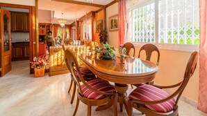 Un comedor con una mesa redonda de madera, seis sillas y un candelabro.