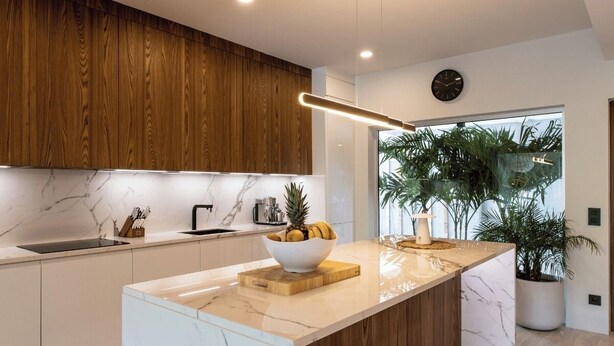 A modern kitchen with wooden cabinets, a marble countertop, and a central island with a bowl of fruit. - 2 rooms with private pool | Villa 2 (Pigeon-Pea Hill)