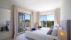 A modern hotel room with a large bed, a desk, and a balcony with a view. - Nice apartment for 6 guests with pool, A/C, WIFI, TV and terrace (Quarteira)