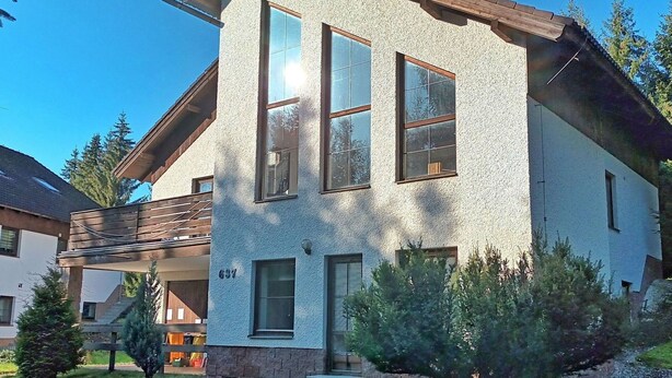 A two-story house with a stone facade, large windows, and a wooden deck. - Nice apartment for 12 people with WIFI and pets allowed (Jilemnice)