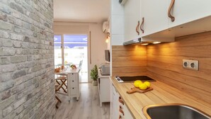A modern kitchen with a brick wall, wooden countertop, and stainless steel sink.