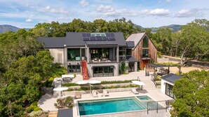 A modern house with a swimming pool, solar panels, and a large deck area. - Luxury Villa | Pool, Hot Tub & Views | Glen Ellen | 4BR | Sleeps 8 (Glen Ellen)