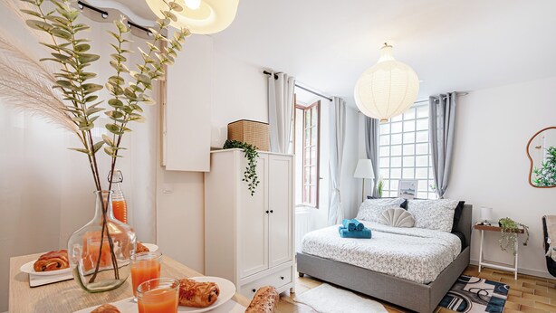 Una camera da letto moderna con un letto, un comodino e una finestra con tende.