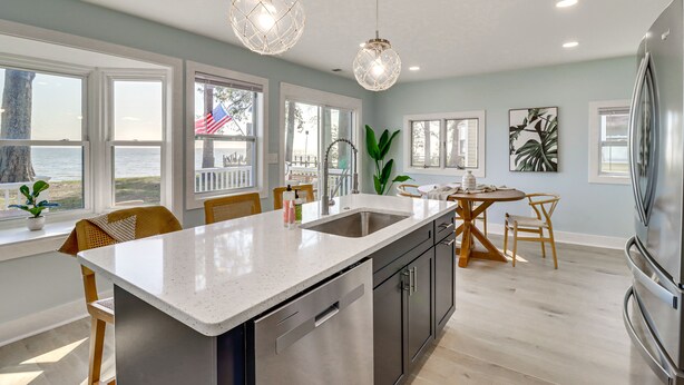 A modern kitchen with a large island, stainless steel appliances, and pendant lighting. - Bayfront Maryland Retreat w/ Deck, Near Beaches! (North Beach)