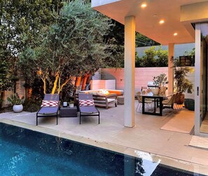 A modern outdoor pool area with lounge chairs, a barbecue, and a dining table. - Stunning Home: Pool, Hot Tub, Fire Pit, Dogs OK (Los Angeles)