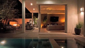A modern outdoor living area with a pool, seating, and a fire feature. - Stunning Home: Pool, Hot Tub, Fire Pit, Dogs OK (Los Angeles)