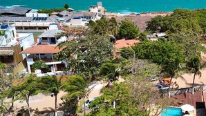 Una propiedad costera con piscina, abundante vegetación y vistas al océano.