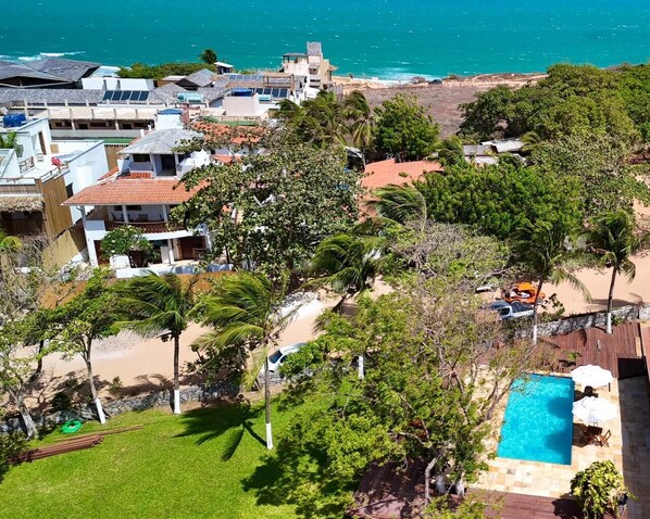Ein Küsteneigentum mit Pool, üppiger Bepflanzung und Meerblick.