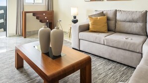 A living room with a sofa, a wooden coffee table, two vases, a lamp, and two framed artworks on the wall. - Cantinho do Sol by Homie (Ribeira Brava)