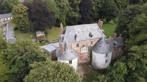 An aerial view of a large, historic estate with multiple buildings, including a prominent tower and a main house with a steeply pitched roof. - A castle just for you! (Bouillancourt-en-Séry)