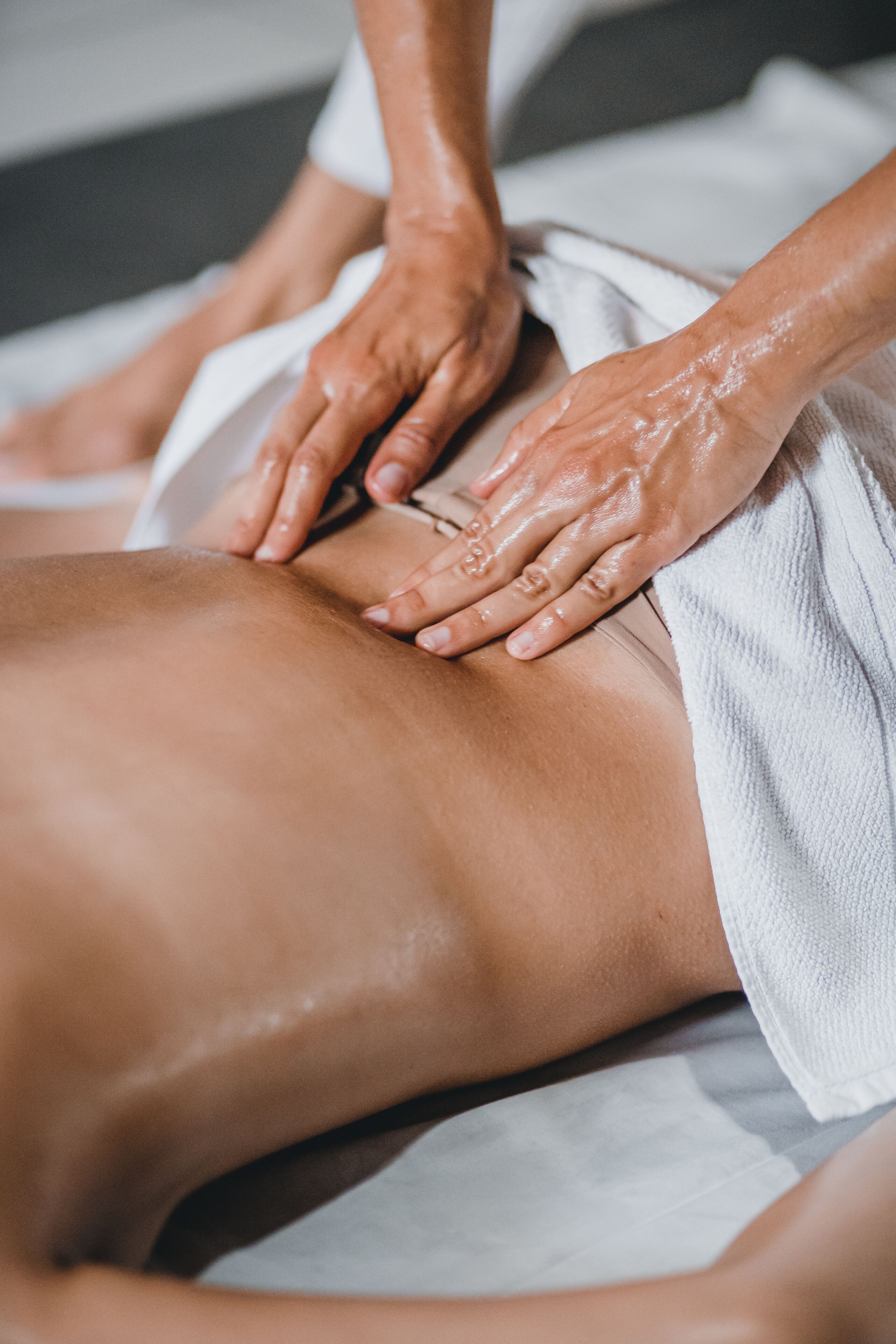 A massage therapy session with a towel covering the client.