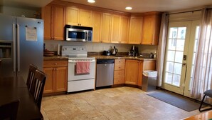 A kitchen with wooden cabinets, a stainless steel refrigerator, a microwave, a stove, and a dishwasher. - 3 Bedroom Basement Suite with Kitchen (Centerville)