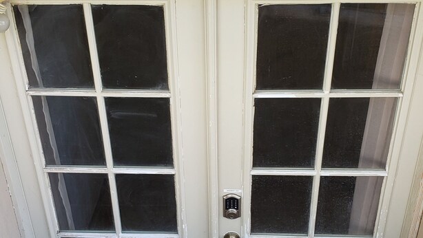 A double door with a keypad lock and a doormat. - 3 Bedroom Basement Suite with Kitchen (Centerville)