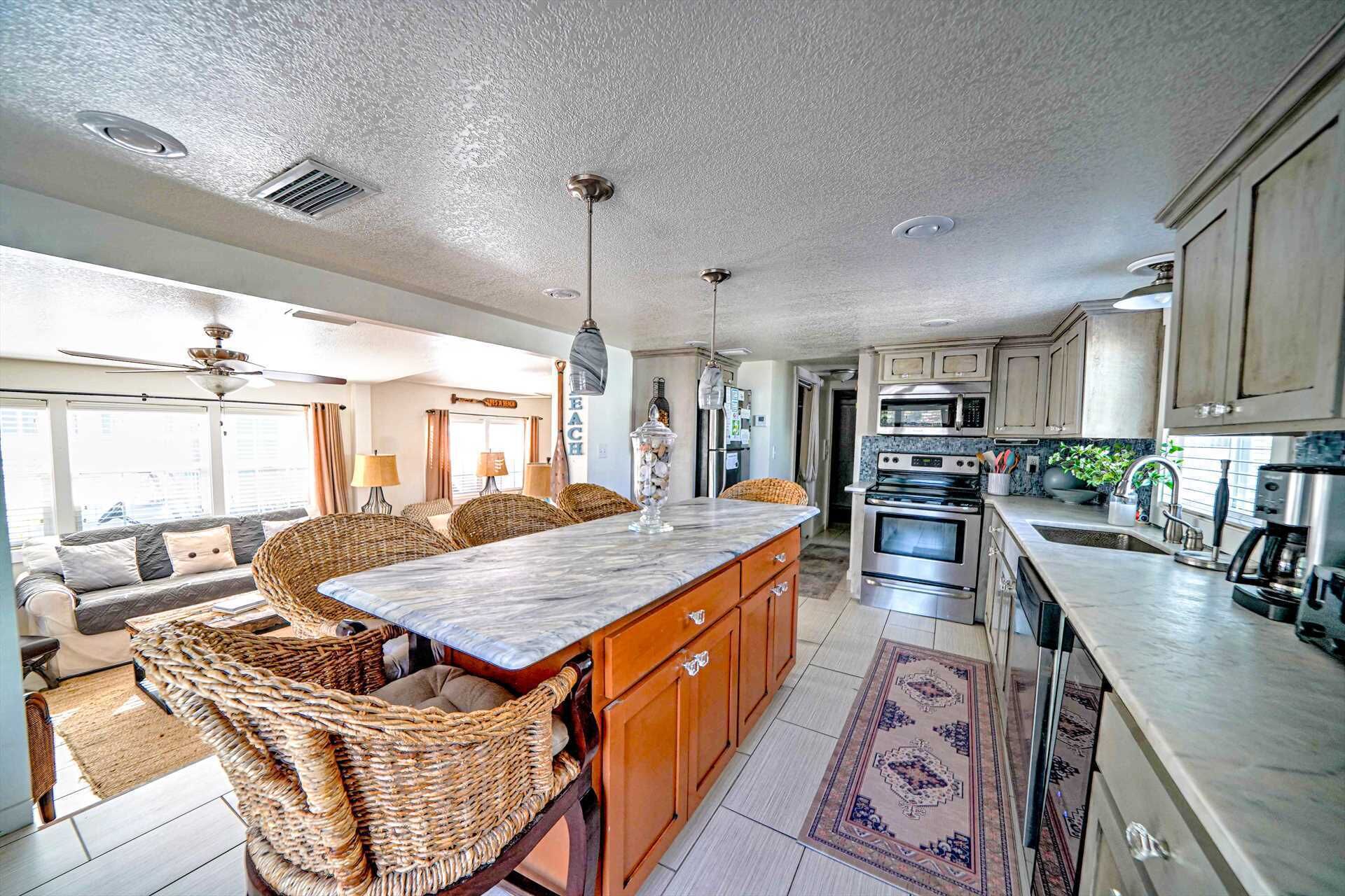 A spacious kitchen with a large island, modern appliances, and a view to the living area.