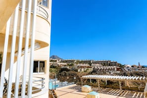 A hotel with a pool area, outdoor seating, and a view of the surrounding buildings and landscape.