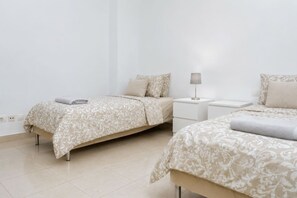 Une chambre d’hôtel avec deux lits, une table de chevet et une lampe.
