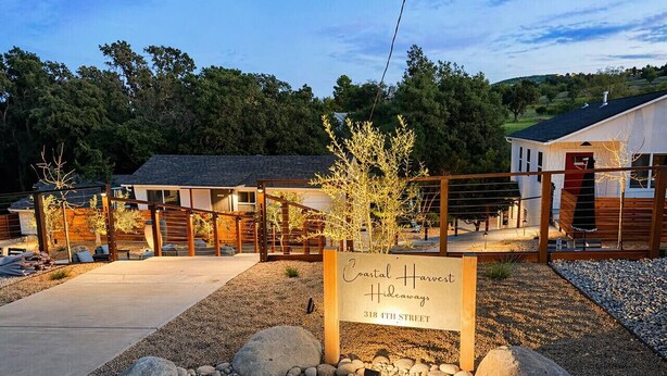 A sign for Coastal Harvst Hideaways at 318th Street, surrounded by a gravel area and wooden structures. - 2Bed 2 Bath Cottage onMicro Resort near Downtown (Paso Robles)
