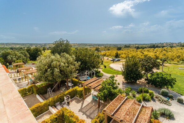 A rooftop garden with pergolas, seating areas, and a view of the surrounding landscape.