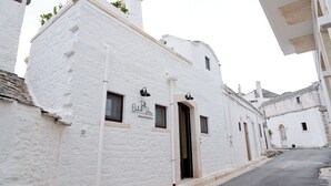 A white building with a sign that reads "Ochel Palace Hotel & Spa" and a door. - TrulliOcchiDiPietraHistoricalExperience (Alberobello)