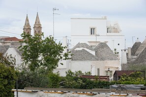 A traditional building with a white facade, a stone tower, and a modern extension. - TrulliOcchiDiPietraHistoricalExperience (Alberobello)