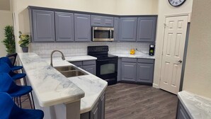 A modern kitchen with grey cabinets, a stainless steel sink, a black stove, and a microwave. - FIFA 2026‼️ Modern 3 bedroom home for stay! AT&T Stadium, Globe Life Field. (Mansfield)