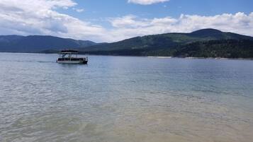 Um barco em um lago calmo, com montanhas ao fundo.