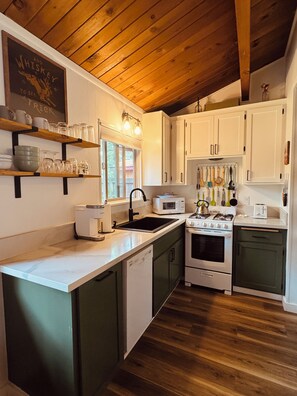 Une cuisine avec des meubles en bois, un four à micro-ondes, un évier et une cuisinière.
