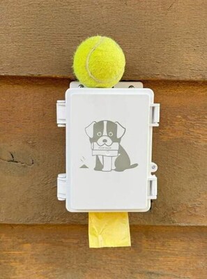 Una caja blanca con una ilustración de un perro y una pelota de tenis encima.