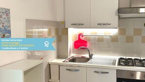 A kitchen with white cabinets, a stainless steel sink, and a red hanging rack. - M383 - Marcelli, comfortable three-room apartment 200mt from the sea (Marcelli)