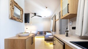 Una cucina moderna con mobili in legno, forno integrato e ventola a soffitto.