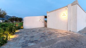 Un edificio moderno con una facciata curva e un ingresso lastricato in pietra.