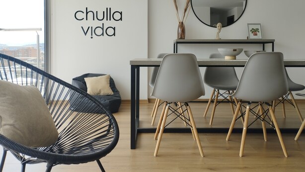 A modern living room with a dining area, a black chair, grey chairs, a sofa, and a wall-mounted mirror. - Cozy and new Condo. La Carolina 10th floor Unbeatable view.  (Quito)