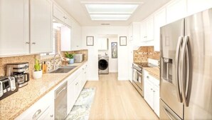 A modern kitchen with white cabinets, stainless steel appliances, and a central island.