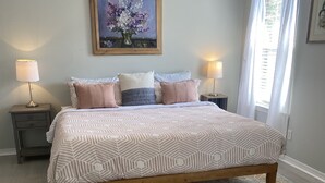 A bedroom with a bed, nightstands, a rug, and a painting on the wall. - Spacious Navarre Home (Navarre)