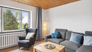 A living room with a grey sofa, a grey armchair, and a wooden coffee table. - 3 bedroom lovely home in Saal (Saal)