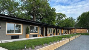 A row of modern, two-story buildings with large windows and a well-maintained lawn. - Nordic Harbor | Room 5 | Cedar Shadows (Center City)