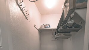 A narrow hallway with a wooden floor, a trash bin, and a ceiling fan. - Beautiful Downtown San Diego Studio (San Diego)