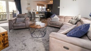 Una sala de estar con dos sofás, una mesa de centro y un comedor con sillas y una mesa.