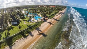 An aerial view of a coastal resort with a swimming pool, beach, and ocean. - Flats Beach Class Resort - Muro Alto (Ipojuca)