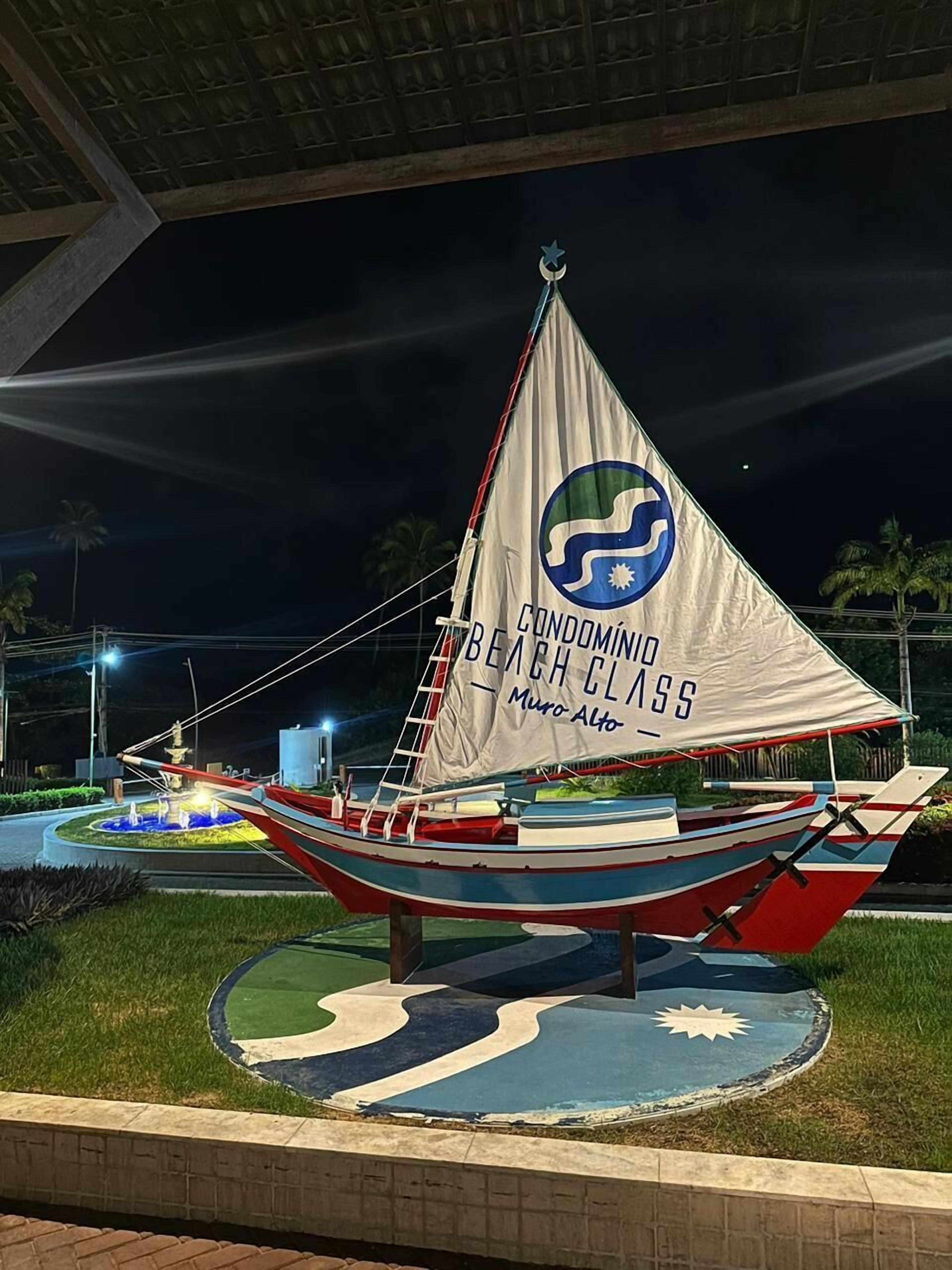 Un modelo de velero con una bandera que dice "CONDOMINIUM BEACH CLASS" y "Muro Alto".