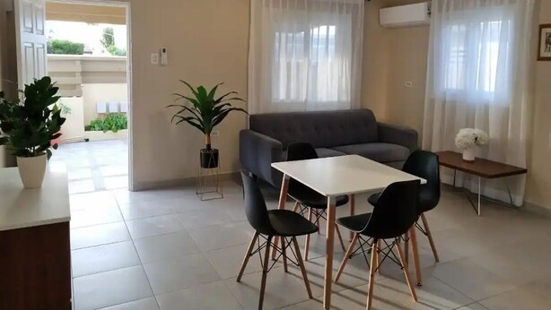 A modern living room with a sofa, dining table, chairs, and a potted plant. - Taminaka Comfortable III (Oranjestad)