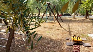 Ein Spielplatz mit Schaukeln und einer Wippe.