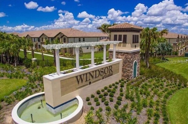 A sign for 'Windsor' with a pool and landscaped garden.