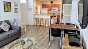 A compact living space with a kitchenette, a dining area, and a seating area with a sofa and coffee table. - 4 Bedroom 3 Bathroom Villas At Seven Dwarfs 17-107 (Kissimmee)