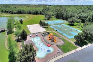 Ein Park mit Basketballplatz, Spielplatz und einem kleinen Teich.