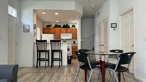 A compact living space with a dining area, kitchen, and a small seating area. - 4 Bedroom 3 Bathroom Villas At Seven Dwarfs 8-107 (Kissimmee)